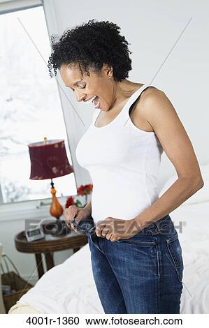 Mid adult woman measuring her weight on a weighing scale View Large Photo Image Stock Image - Mid adult woman measuring her weight on a weighing scale. Fotosearch