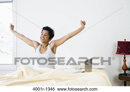 Mid adult woman stretching on the bed View Large Photo Image Stock Photography - Mid adult woman stretching on the bed. Fotosearch