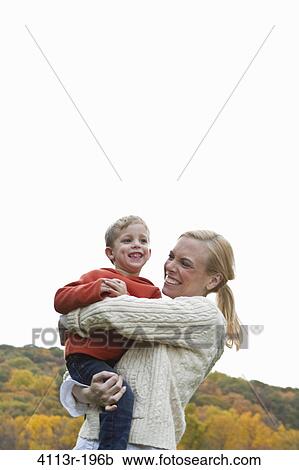 Mother playing with son outdoors View Large Photo Image Stock Image - Mother playing with son outdoors. Fotosearch