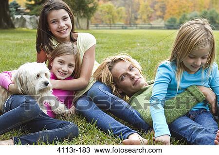 Mother with three daughters and dog relaxing on grass View Large Photo Image Stock Image - Mother with three daughters and dog relaxing on grass. Fotosearch