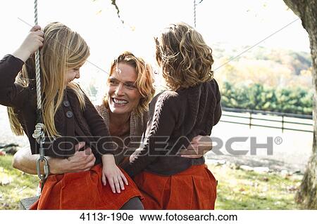 Mother with two daughters on swing View Large Photo Image Stock Image - Mother with two daughters on swing. Fotosearch