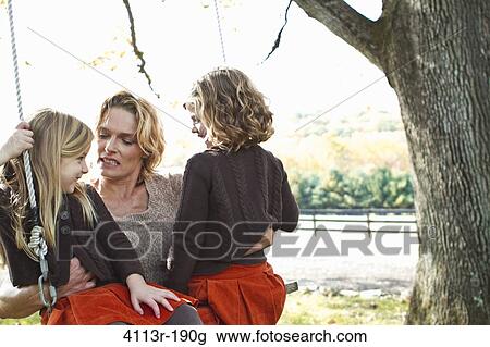 Mother with two daughters on swing View Large Photo Image Stock Image - Mother with two daughters on swing. Fotosearch