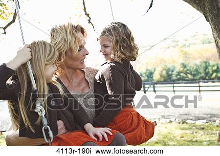 Mother with two daughters on swing View Large Photo Image Stock Image - Mother with two daughters on swing. Fotosearch