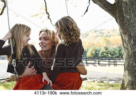 Mother with two daughters on swing View Large Photo Image Stock Image - Mother with two daughters on swing. Fotosearch