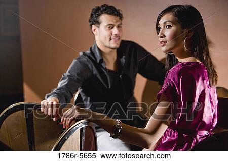 Multiracial couple sitting on bar stools View Large Photo Image Stock Photography - Multiracial couple sitting on bar stools. Fotosearch