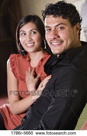 Multiracial couple sitting on couch together View Large Photo Image Stock Image - Multiracial couple sitting on couch together. Fotosearch