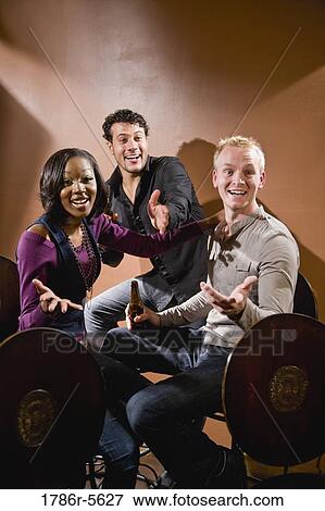 Stock Photo - Multiracial friends smiling and gesturing. Fotosearch