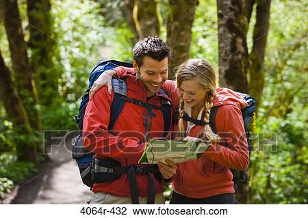 Stock Image - Portland, Oregon, USA, Couple hiking, stopping to reading map. Fotosearch