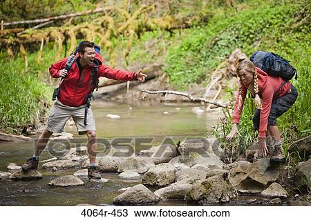 Portland, Oregon, USA, Man helping woman across creek View Large Photo Image Stock Image - Portland, Oregon, USA, Man helping woman across creek. Fotosearch