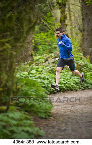 Stock Photo - Portland, Oregon, USA, Man trail running in forest. Fotosearch