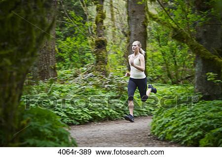 Stock Photo - Portland, Oregon, USA, Woman trail running in forest. Fotosearch