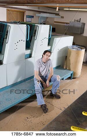 Portrait of a blue-collar man sitting next to a printing press View Large Photo Image Stock Photo - Portrait of a blue-collar man sitting next to a printing press. Fotosearch