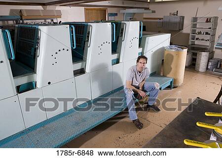 Portrait of a blue-collar man sitting next to a printing press View Large Photo Image Stock Photo - Portrait of a blue-collar man sitting next to a printing press. Fotosearch