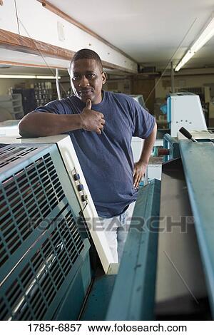 Portrait of a blue-collar man standing behind a printing machine View Large Photo Image Stock Photo - Portrait of a blue-collar man standing behind a printing machine. Fotosearch