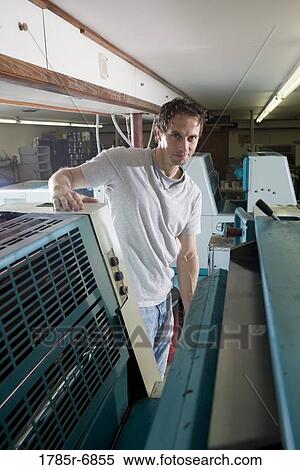 Portrait of a blue-collar man standing behind a printing machine View Large Photo Image Stock Photography - Portrait of a blue-collar man standing behind a printing machine. Fotosearch