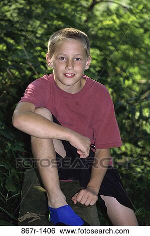Portrait of a boy sitting on a ledge View Large Photo Image Stock Photograph - Portrait of a boy sitting on a ledge. Fotosearch