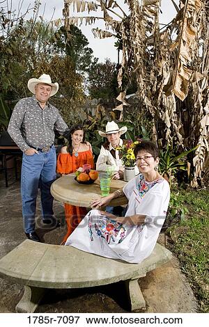 Portrait of a cheerful Tex-Mex family sitting together in the backyard of house View Large Photo Image Stock Photo - Portrait of a cheerful Tex-Mex family sitting together in the backyard of house. Fotosearch
