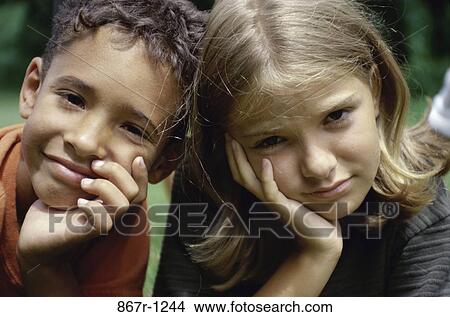 Portrait of a girl and a boy with their hands on their chins View Large Photo Image Picture - Portrait of a girl and a boy with their hands on their chins. Fotosearch