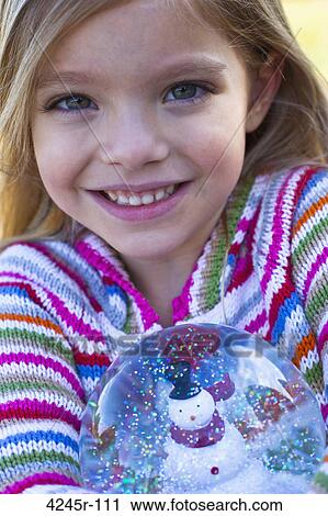 Portrait of a girl holding a snow globe and smiling View Large Photo Image Stock Image - Portrait of a girl holding a snow globe and smiling. Fotosearch