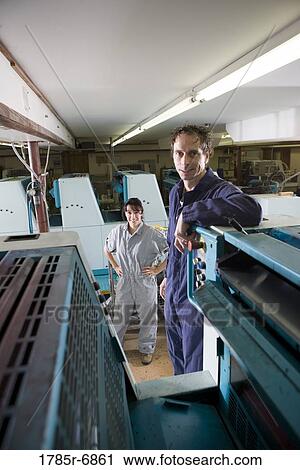 Portrait of a man and a woman in coveralls behind a printing machine View Large Photo Image Stock Image - Portrait of a man and a woman in coveralls behind a printing machine. Fotosearch