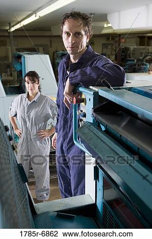 Portrait of a man and a woman in coveralls behind a printing machine View Large Photo Image Stock Image - Portrait of a man and a woman in coveralls behind a printing machine. Fotosearch