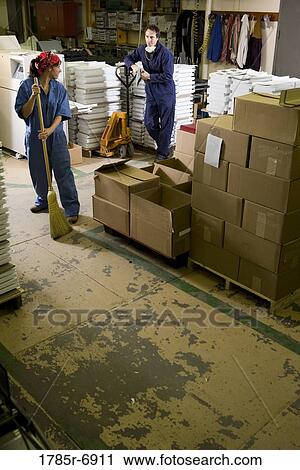Portrait of a man and a woman in coveralls working in a warehouse View Large Photo Image Stock Image - Portrait of a man and a woman in coveralls working in a warehouse. Fotosearch