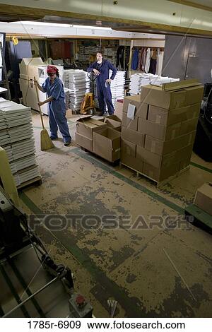 Portrait of a man and a woman in coveralls working in a warehouse View Large Photo Image Stock Photo - Portrait of a man and a woman in coveralls working in a warehouse. Fotosearch