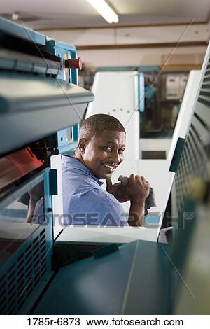 Portrait of a man in coveralls sitting behind a printing machine View Large Photo Image Stock Image - Portrait of a man in coveralls sitting behind a printing machine. Fotosearch