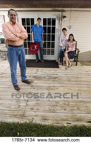 Portrait of a mature couple with their adult children at the doorway of their house View Large Photo Image Picture - Portrait of a mature couple with their adult children at the doorway of their house. Fotosearch