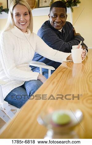Portrait of a mature inter-racial couple with coffee cups at a kitchen counter View Large Photo Image Stock Photo - Portrait of a mature inter-racial couple with coffee cups at a kitchen counter. Fotosearch