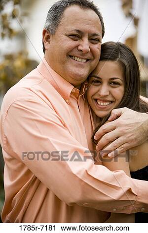 Stock Image - Portrait of a smiling father embracing his daughter. Fotosearch