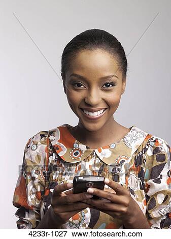 Portrait of a smiling young woman using phone over colored background View Large Photo Image Stock Photo - Portrait of a smiling young woman using phone over colored background. Fotosearch