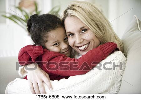 Portrait of a woman embracing her daughter View Large Photo Image Stock Photo - Portrait of a woman embracing her daughter. Fotosearch