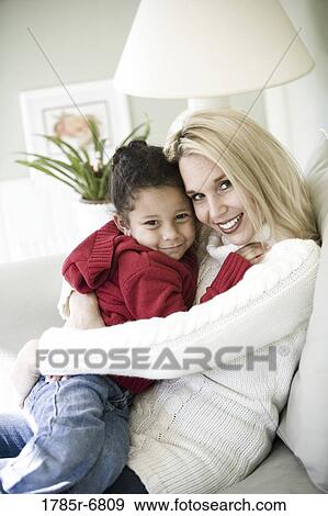 Stock Photo - Portrait of a woman embracing her daughter. Fotosearch
