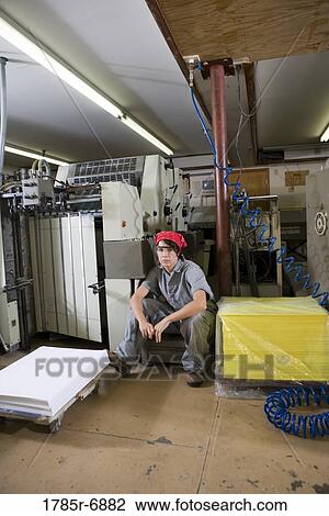 Portrait of a woman in coveralls sitting next to some machinery View Large Photo Image Stock Image - Portrait of a woman in coveralls sitting next to some machinery. Fotosearch