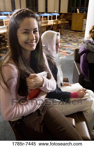 Portrait of a woman student in a sitting lounge in a library with friends View Large Photo Image Stock Photography - Portrait of a woman student in a sitting lounge in a library with friends. Fotosearch