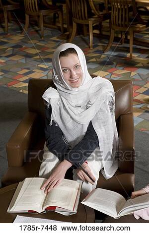 Portrait of a woman student wearing a head scarf in a sitting lounge in a library View Large Photo Image Stock Photo - Portrait of a woman student wearing a head scarf in a sitting lounge in a library. Fotosearch