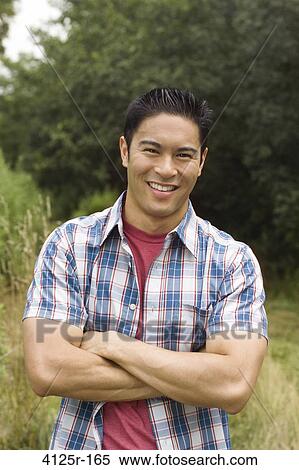 Stock Photography - Portrait of a young man smiling in a field. Fotosearch