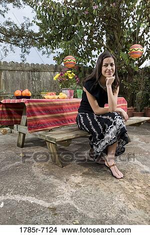 Portrait of a young woman sitting in front of a picnic table View Large Photo Image Picture - Portrait of a young woman sitting in front of a picnic table. Fotosearch