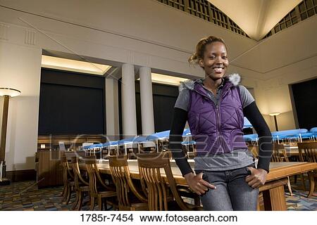 Portrait of a young woman standing in the reading room of a library View Large Photo Image Picture - Portrait of a young woman standing in the reading room of a library. Fotosearch