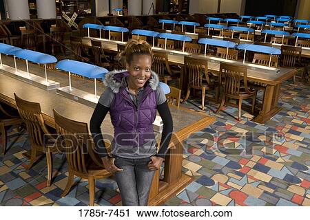 Portrait of a young woman standing in the reading room of a library View Large Photo Image Stock Image - Portrait of a young woman standing in the reading room of a library. Fotosearch
