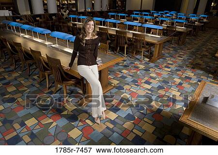 Portrait of a young woman standing in the reading room of a library View Large Photo Image Stock Photo - Portrait of a young woman standing in the reading room of a library. Fotosearch