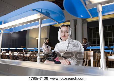 Portrait of a young woman student in a library View Large Photo Image Stock Photograph - Portrait of a young woman student in a library. Fotosearch