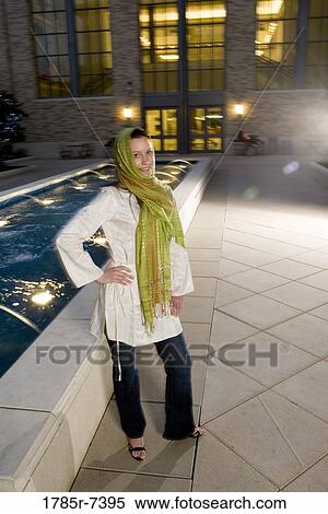 Portrait of a young woman wearing a head scarf smiling, standing by a fountain View Large Photo Image Stock Photography - Portrait of a young woman wearing a head scarf smiling, standing by a fountain. Fotosearch