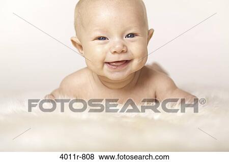 Stock Photo - Portrait of baby boy lying on sheep fur. Fotosearch
