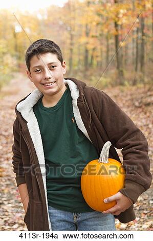 Portrait of boy carrying pumpkin in forest View Large Photo Image Stock Image - Portrait of boy carrying pumpkin in forest. Fotosearch