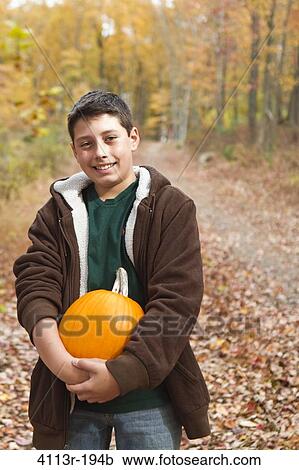 Portrait of boy carrying pumpkin in forest View Large Photo Image Stock Image - Portrait of boy carrying pumpkin in forest. Fotosearch