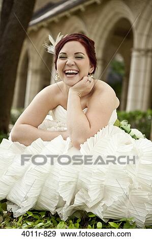 Stock Photo - Portrait of bride sitting in front of church. Fotosearch