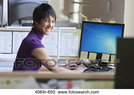 Portrait of businesswoman using computer at office desk View Large Photo Image Stock Image - Portrait of businesswoman using computer at office desk. Fotosearch