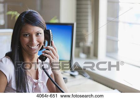 Portrait of businesswoman using telephone in office View Large Photo Image Stock Image - Portrait of businesswoman using telephone in office. Fotosearch